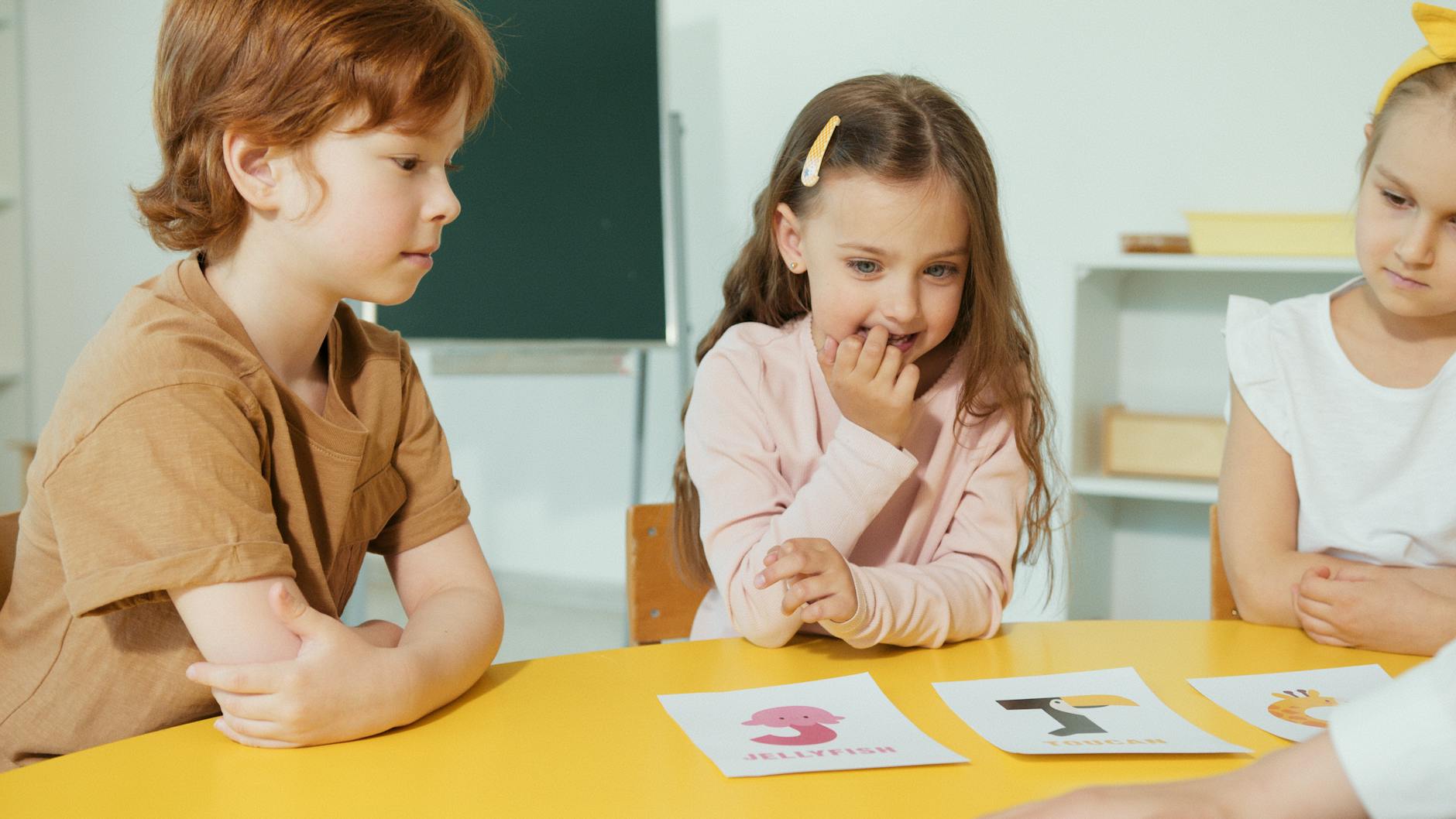 kids looking at the alphabet placards on the table
